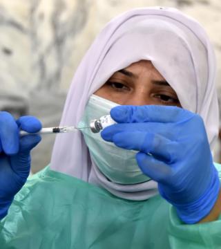 A medical worker prepares a dose of a COVID-19 vaccine in Peshawar, Pakistan, March 2021. Saeed Ahmad Xinhua / eyevine / R​edux