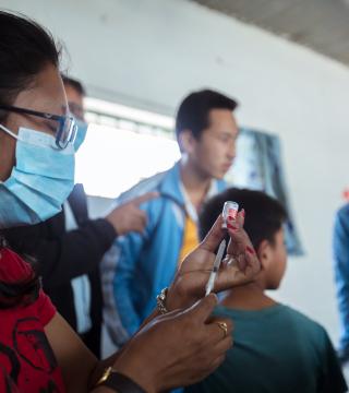 Woman wearing mask prepares vaccine