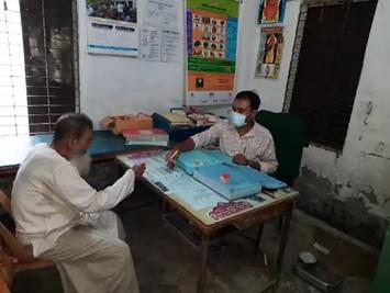 Health worker educates a community member in a health clinic in Bil Dumuria, Bangladesh