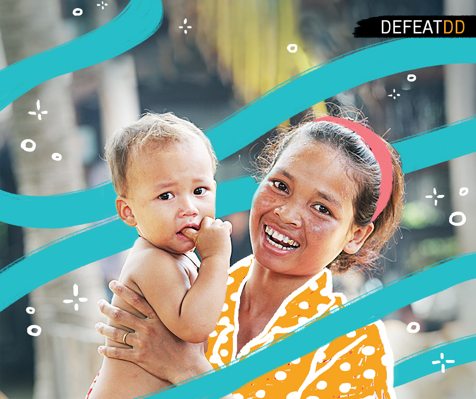 A cheerful woman with a red headband holds a young child who has a finger in their mouth. The background features playful blue waves and white doodles with the word "DEFEATDD" in the top right corner. Both the woman and child appear happy and smiling.