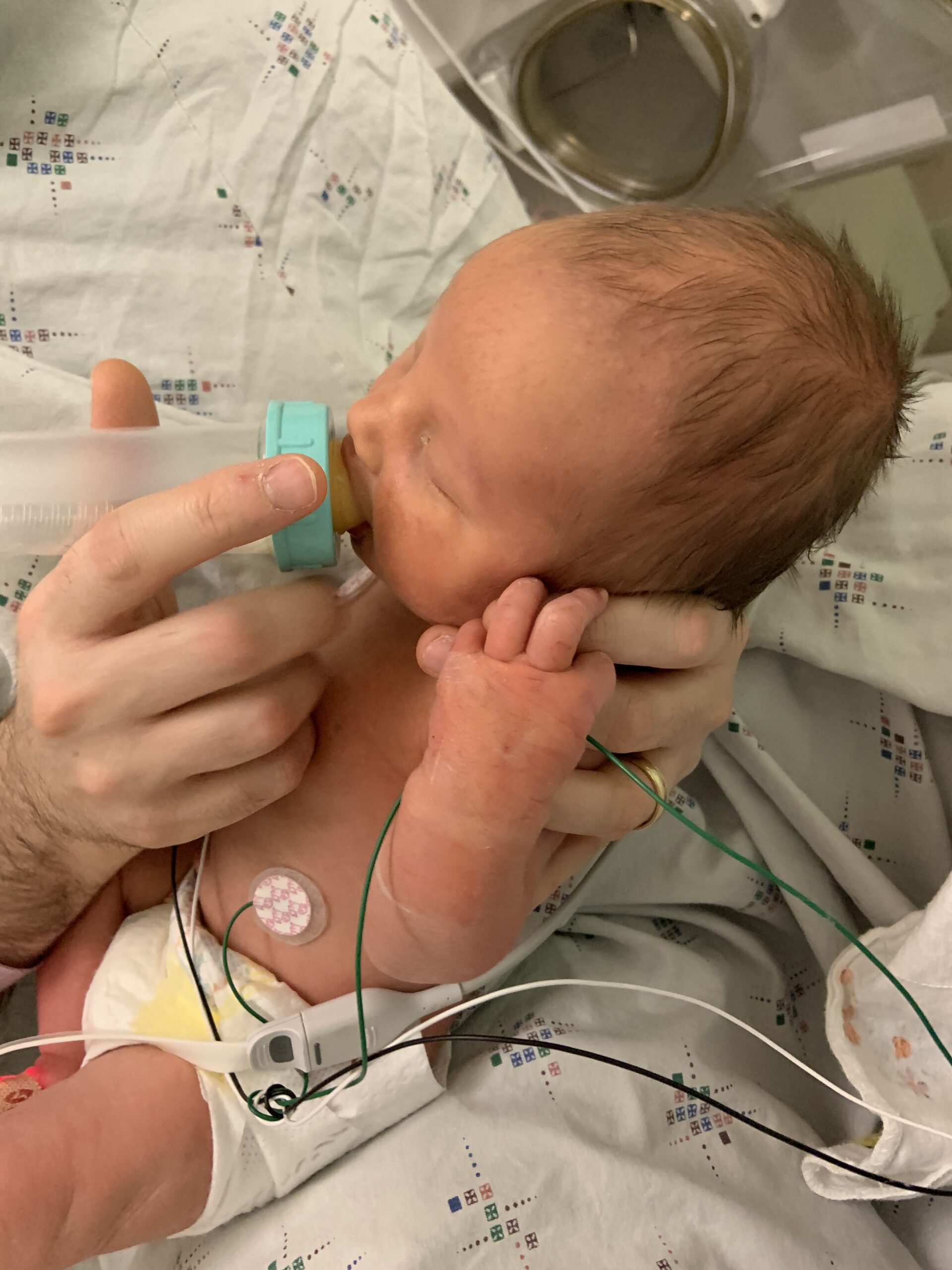 Author's son drinks donor breast milk out of a bottle in the NICU