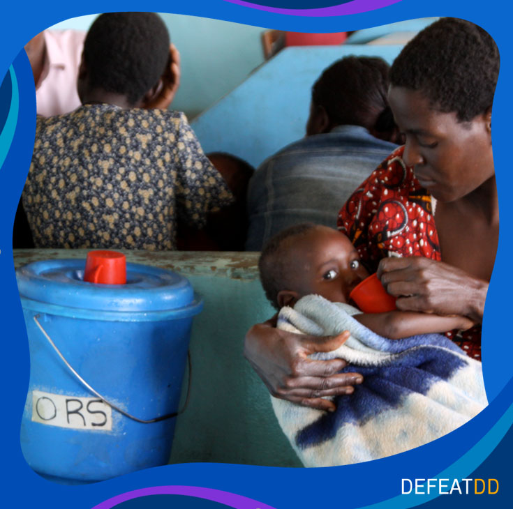 Mother feeding a cup of ORS to her baby