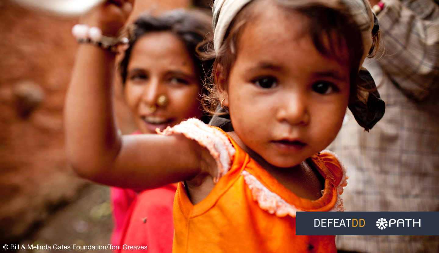 Two young children are pictured close to the camera, with one child in an orange dress in the foreground and another child smiling in the background. The logos of the "Defeat DD" and "PATH" organizations are present along with the © Bill & Melinda Gates Foundation credit.