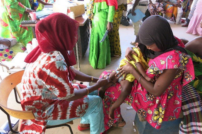 A child held by his mother gets a vaccine