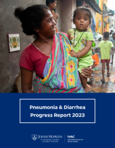 A woman in a colorful saree holds a young child in a green outfit while standing in an urban alley. The image is part of the cover for the "Pneumonia & Diarrhea Progress Report 2023" by Johns Hopkins Bloomberg School of Public Health and IVAC.