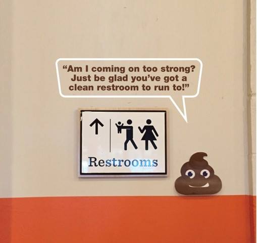 A restroom sign with a gender-neutral figure holding a baby and an arrow pointing upward. Next to the sign is a smiling poop emoji saying, "Am I coming on too strong? Just be glad you've got a clean restroom to run to!.